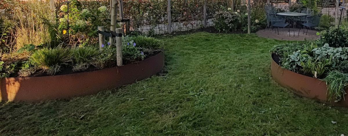 Ronde borders met vaste planten en siergras in dezelfde ecologische tuin