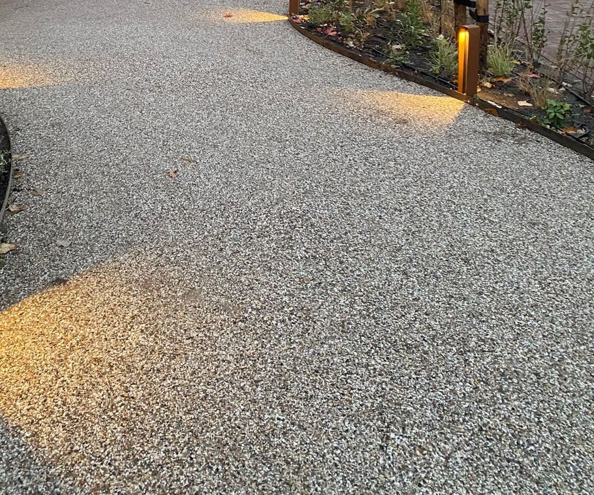 Voortuin in de schemering met een pad en verlichting langs de border